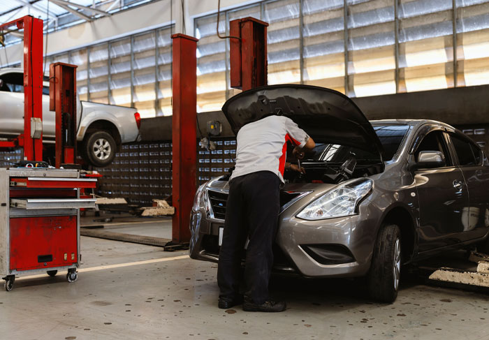 mechanic checking a car to prevent driving emergencies