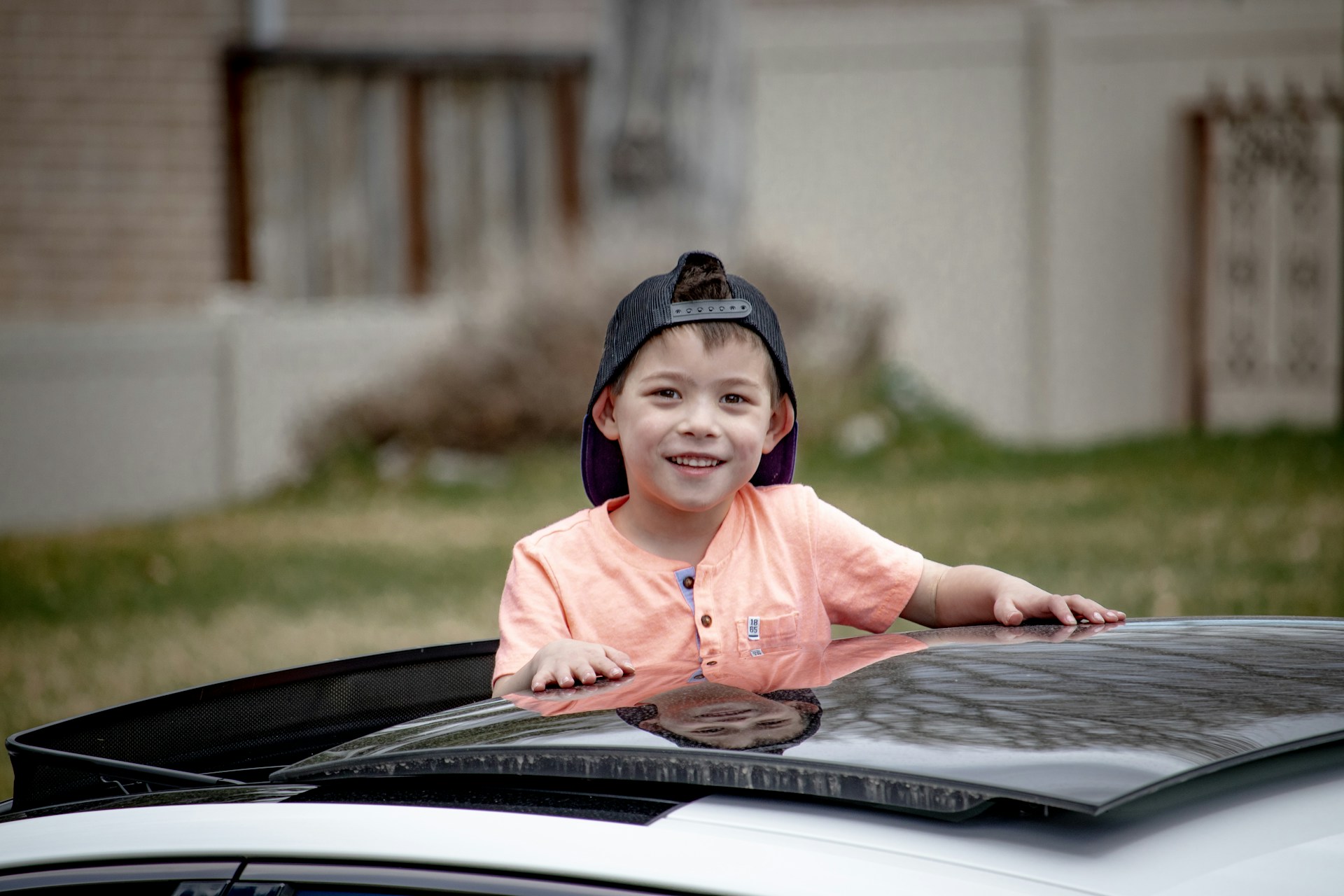 a kid peeking out of a car sunroof